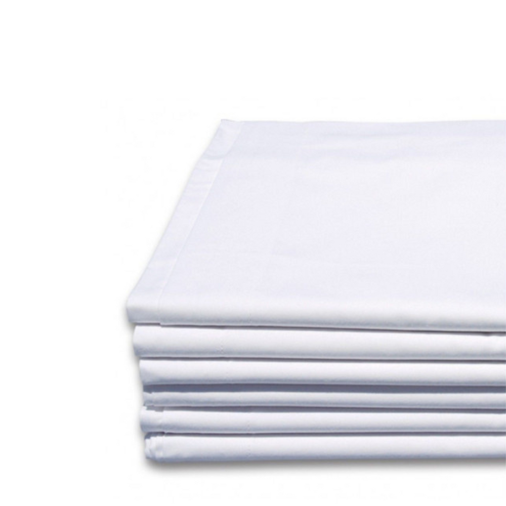 Sábanas de hotel blancas dobladas sobre mesa de lavandería