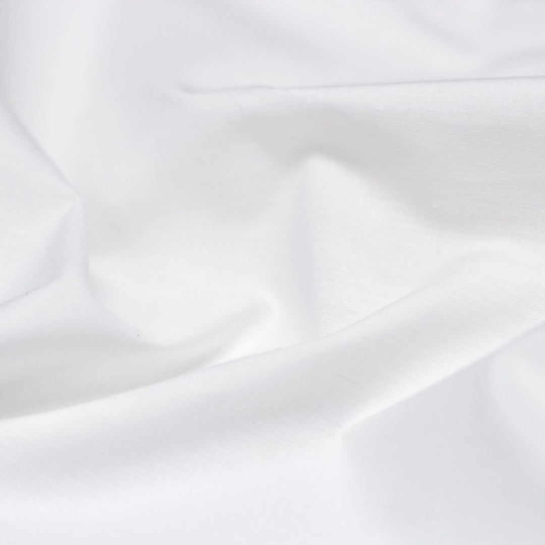 Detail of white cotton-polyester blend fabric of hotel sheets