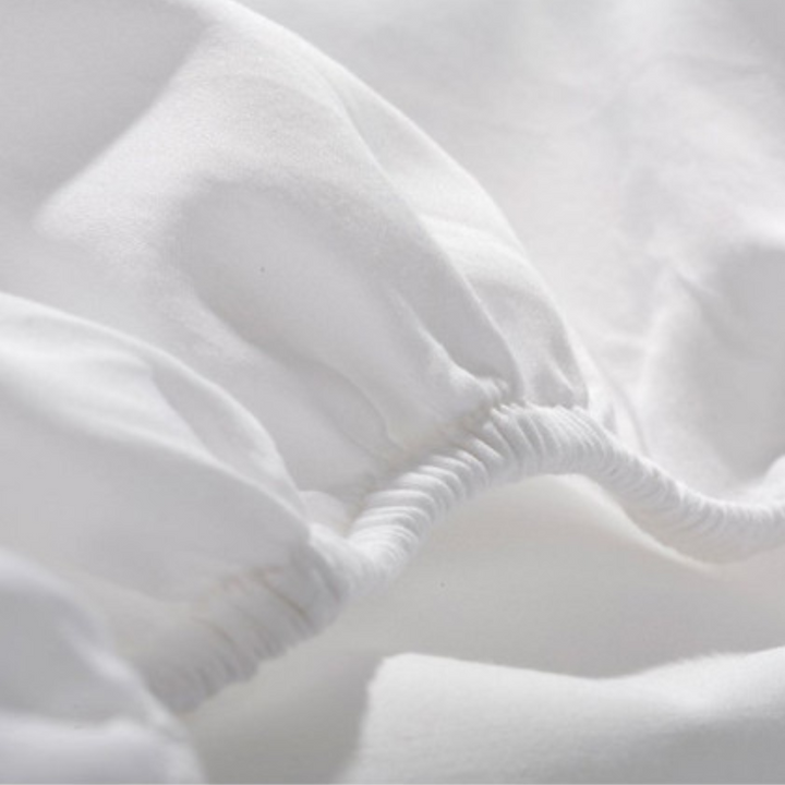 Detail of cotton/polyester blend fabric in white hotel sheets